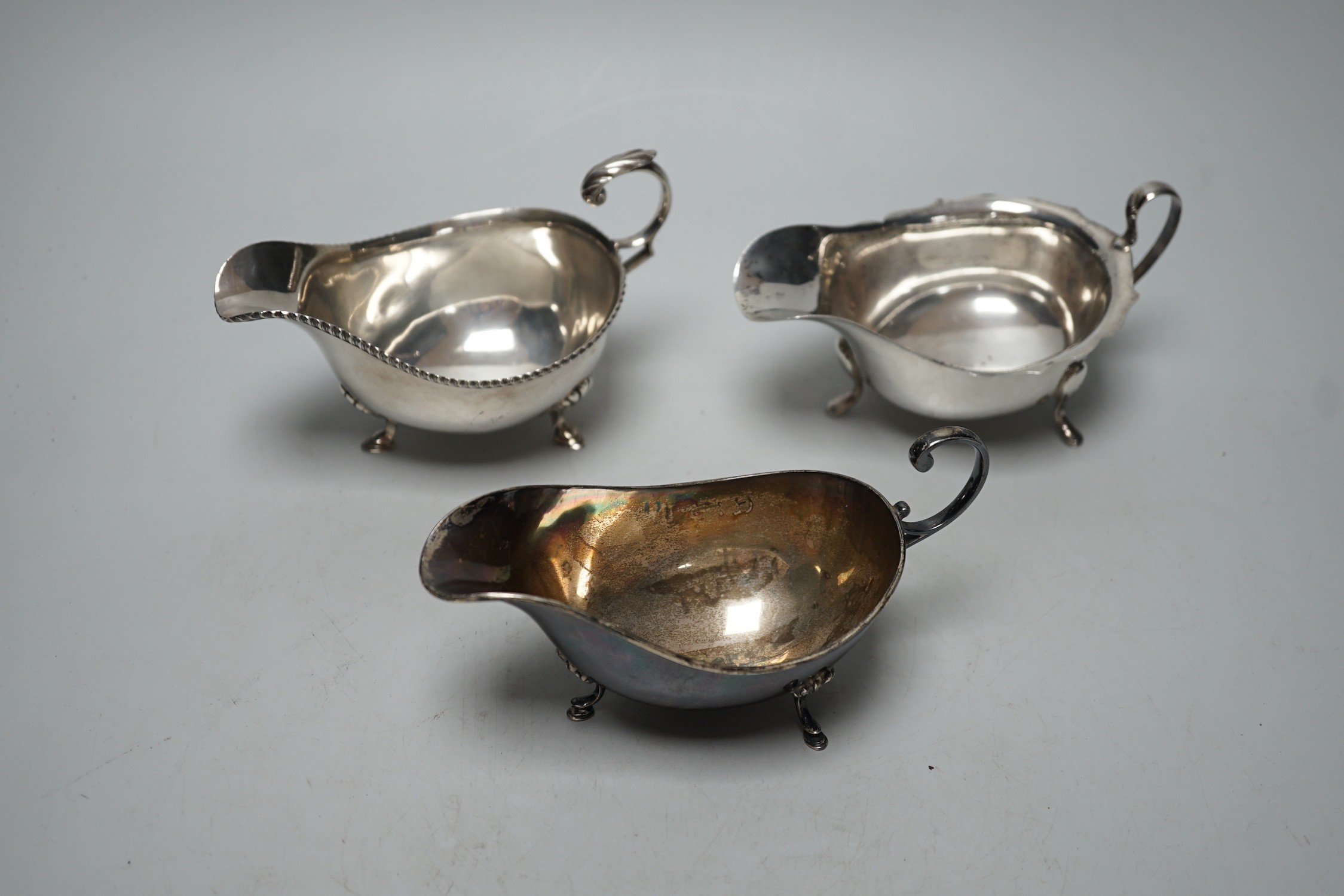 Three assorted 20th century silver sauceboats, longest 14.2cm